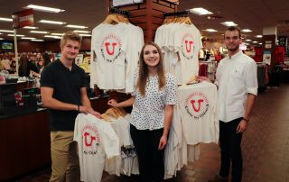 Megan Pollard poses with T-shirts from her company Foster the Children.